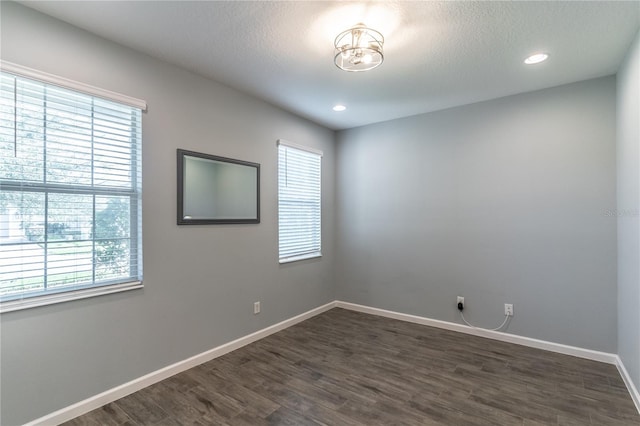 spare room with baseboards, dark wood finished floors, a textured ceiling, and recessed lighting