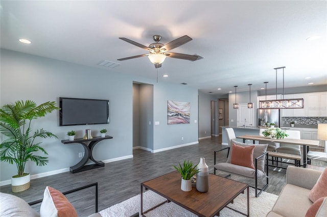 living room featuring ceiling fan, visible vents, wood finished floors, and recessed lighting