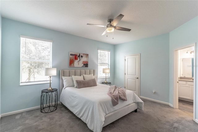 carpeted bedroom with a ceiling fan, connected bathroom, and baseboards