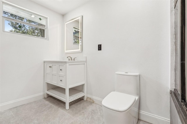 bathroom featuring vanity, toilet, and baseboards