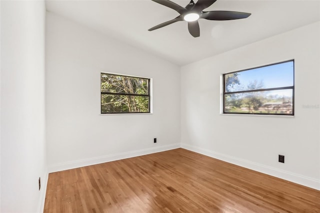 spare room featuring baseboards, a ceiling fan, lofted ceiling, and wood finished floors