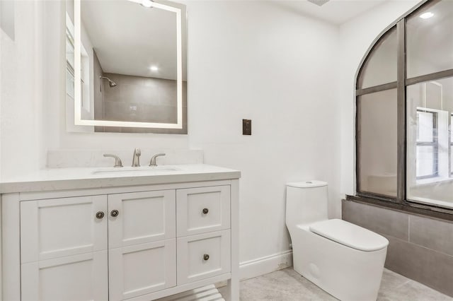 bathroom with vanity, toilet, and a tile shower