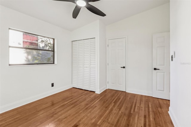 unfurnished bedroom featuring ceiling fan, baseboards, and wood finished floors