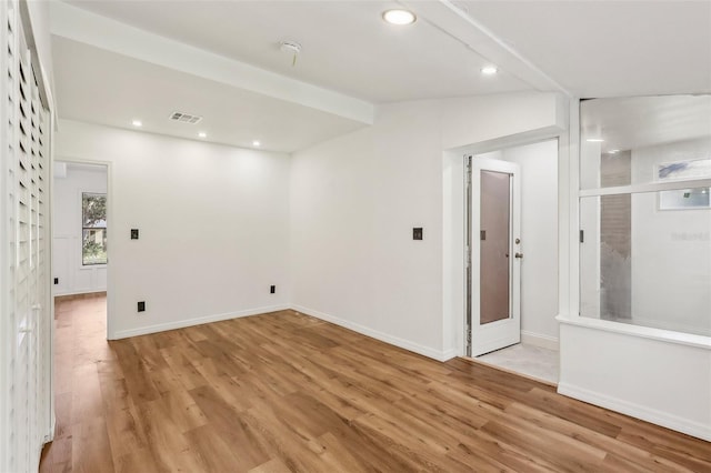 empty room with light wood-type flooring, visible vents, and recessed lighting