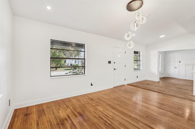 foyer with baseboards, lofted ceiling, and wood finished floors