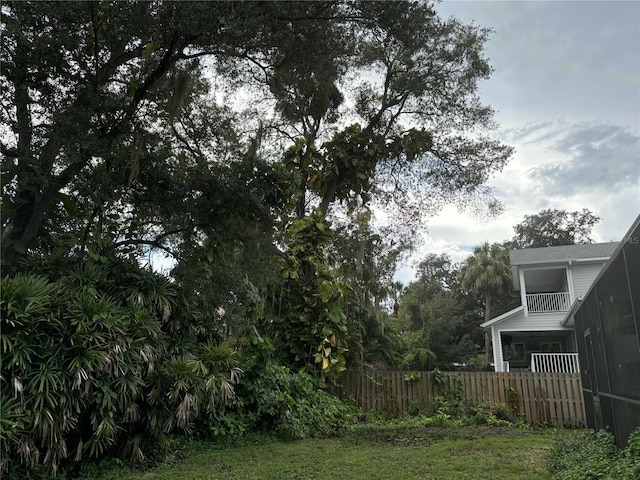 view of yard with a balcony and a sunroom