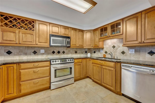 kitchen featuring stainless steel appliances, tasteful backsplash, sink, and stone counters