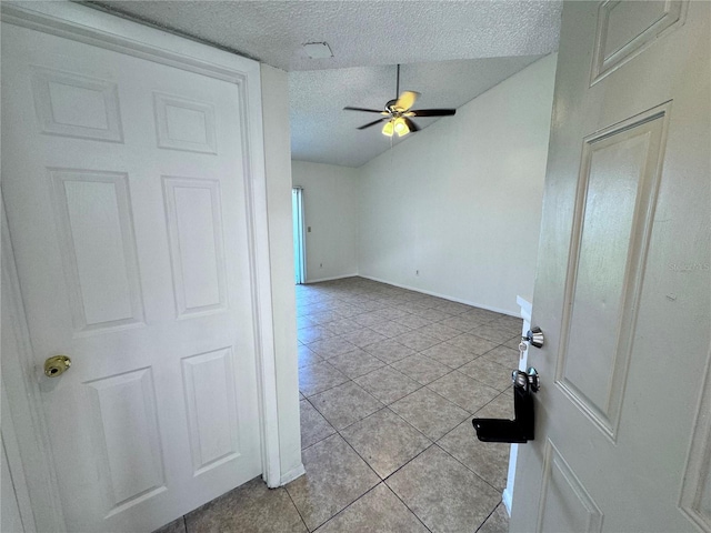 interior space featuring a textured ceiling, ceiling fan, and light tile patterned flooring