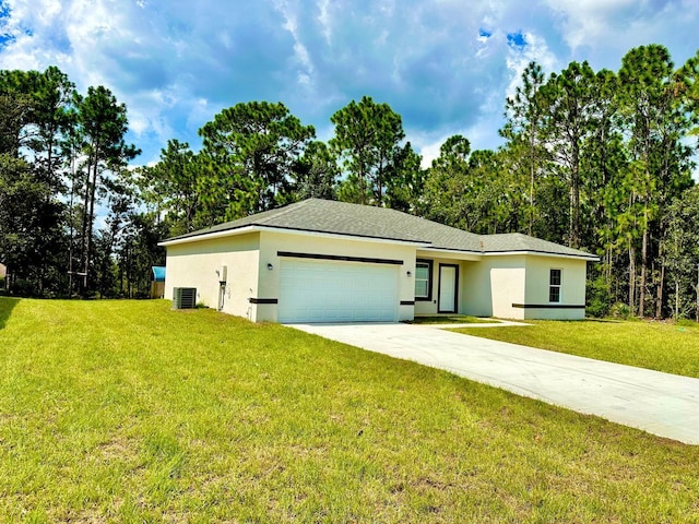 view of front of home with central AC, a front yard, and a garage