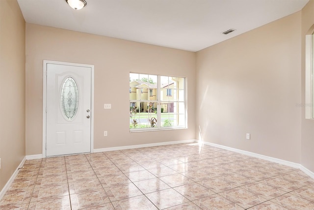 foyer entrance featuring light tile patterned floors, baseboards, and visible vents