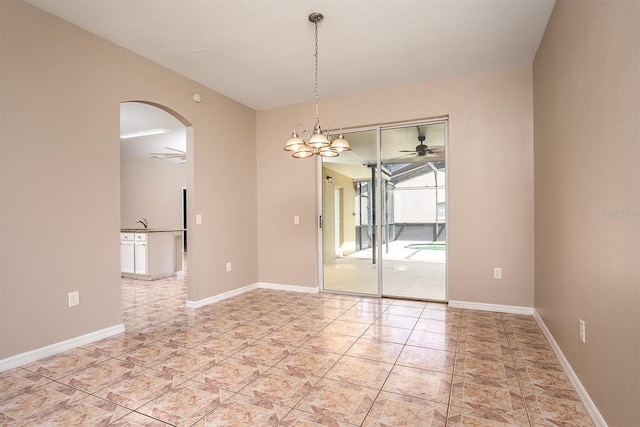 spare room with baseboards, arched walkways, and a ceiling fan