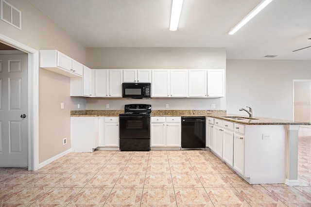 kitchen featuring light stone counters, visible vents, a sink, a peninsula, and black appliances