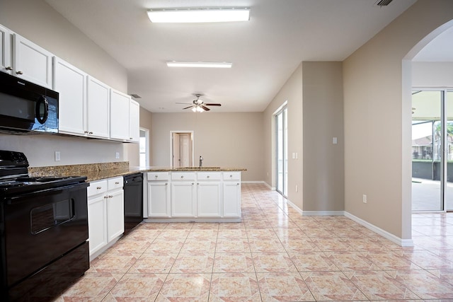 kitchen featuring arched walkways, a peninsula, a sink, white cabinets, and black appliances