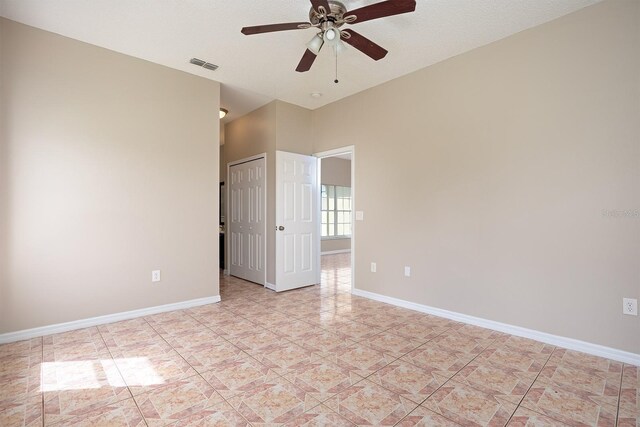 empty room with baseboards, visible vents, ceiling fan, and a textured ceiling