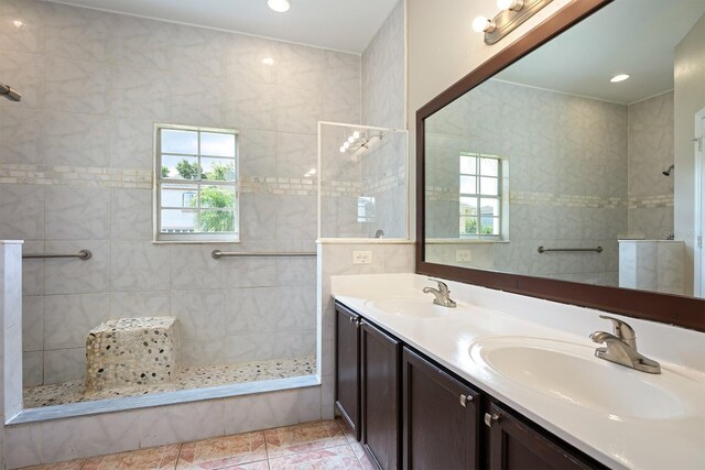 full bathroom featuring double vanity, walk in shower, a sink, and tile patterned floors