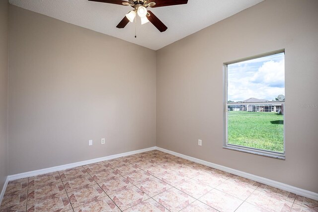 spare room with ceiling fan, baseboards, and light tile patterned floors