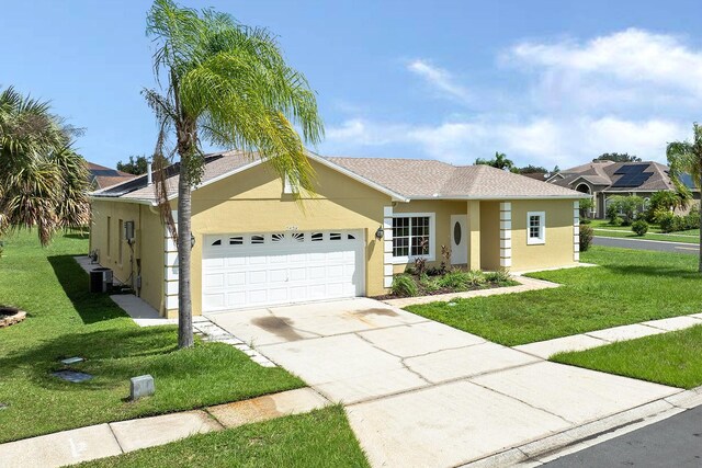 ranch-style home featuring driveway, an attached garage, central air condition unit, a front lawn, and stucco siding