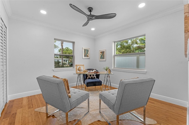 living area with a wealth of natural light, light hardwood / wood-style flooring, and ceiling fan