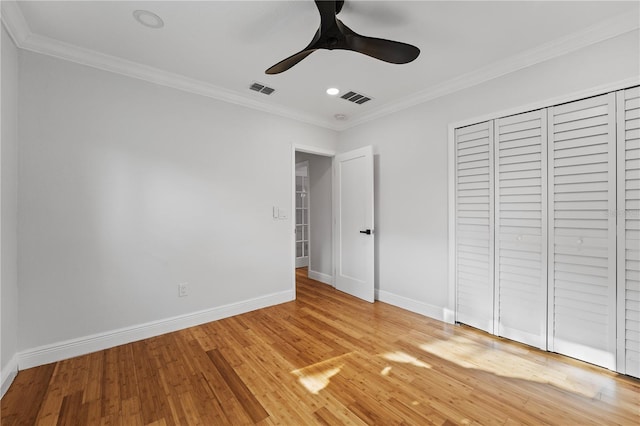 unfurnished bedroom featuring a closet, ceiling fan, ornamental molding, and light hardwood / wood-style flooring