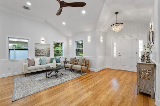 living room featuring high vaulted ceiling, ceiling fan with notable chandelier, light hardwood / wood-style floors, and ornamental molding