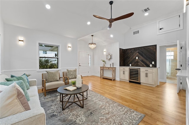 living room with high vaulted ceiling, beverage cooler, ceiling fan, and light hardwood / wood-style floors