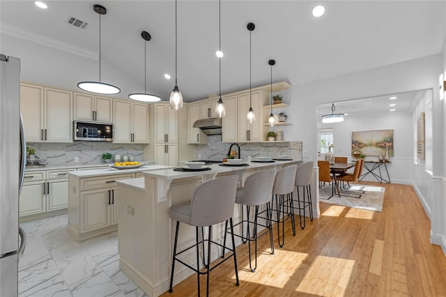 kitchen featuring tasteful backsplash, kitchen peninsula, stainless steel appliances, and a breakfast bar