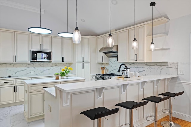 kitchen with a breakfast bar, stainless steel appliances, decorative backsplash, and kitchen peninsula