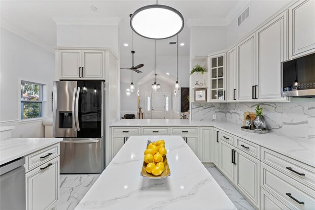 kitchen with white cabinets, decorative light fixtures, stainless steel appliances, and light stone countertops