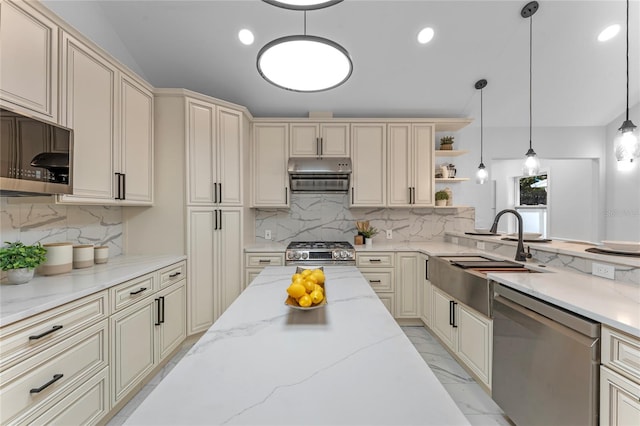 kitchen featuring hanging light fixtures, cream cabinets, appliances with stainless steel finishes, light stone countertops, and sink