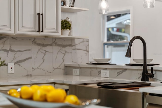 details featuring light stone countertops, backsplash, and white cabinetry