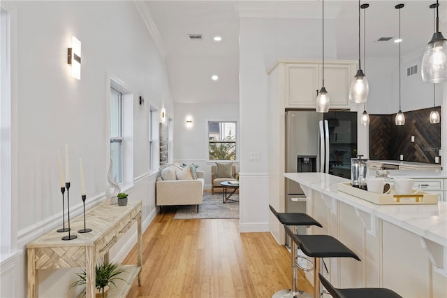 living room with crown molding and light wood-type flooring