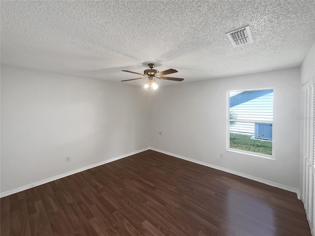 spare room featuring ceiling fan, a textured ceiling, and dark wood-type flooring