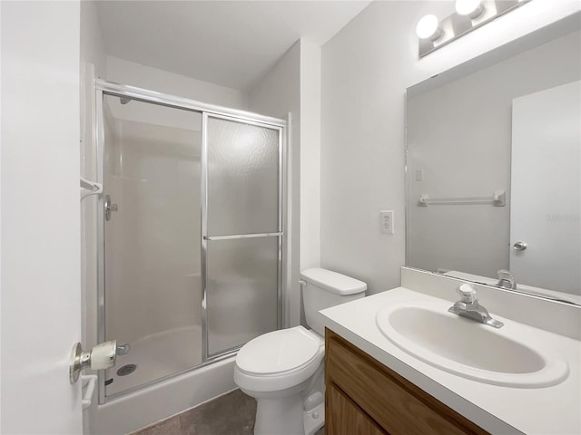 bathroom featuring vanity, toilet, and a shower with shower door