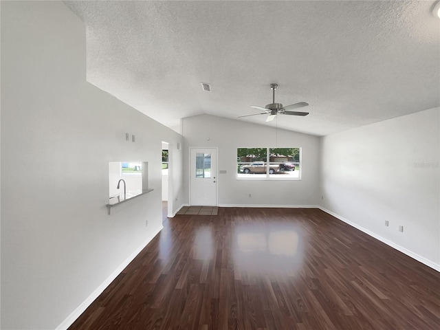 unfurnished living room featuring a wealth of natural light, ceiling fan, a textured ceiling, and dark hardwood / wood-style flooring