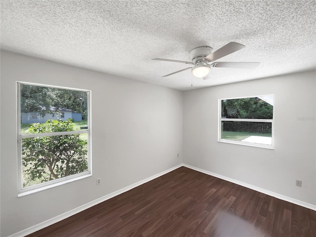 spare room with a ceiling fan, a healthy amount of sunlight, baseboards, and wood finished floors