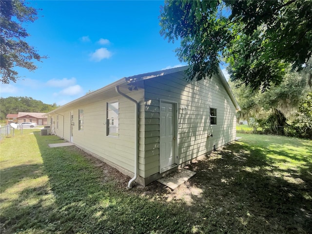 view of property exterior featuring a lawn and fence