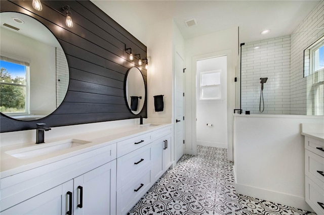 bathroom with vanity, tile patterned floors, a wealth of natural light, and tiled shower