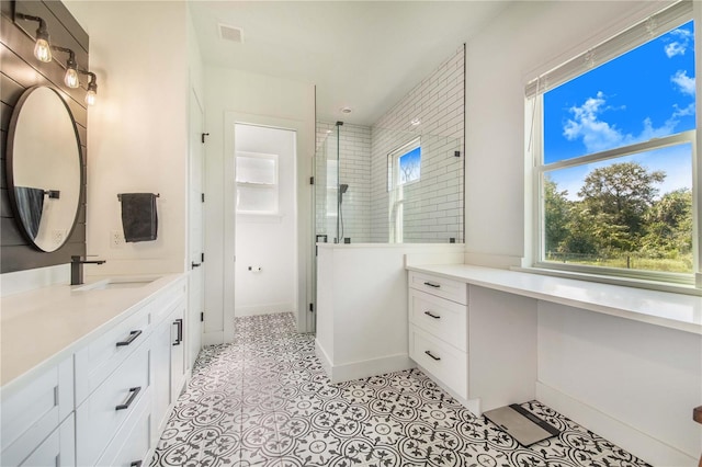 bathroom with tile patterned flooring, walk in shower, a wealth of natural light, and vanity