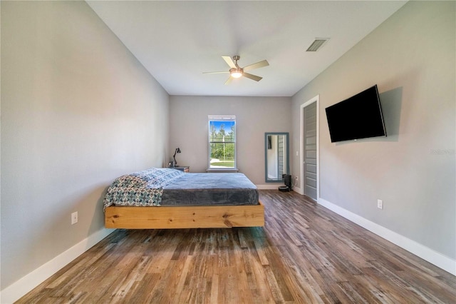 bedroom with dark hardwood / wood-style flooring and ceiling fan