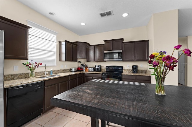 kitchen featuring light stone counters, sink, black appliances, dark brown cabinetry, and light tile patterned floors