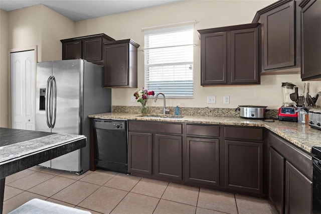 kitchen with light stone counters, light tile patterned floors, black appliances, dark brown cabinets, and sink