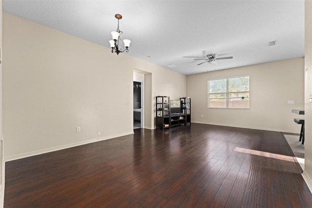 unfurnished living room featuring ceiling fan with notable chandelier and dark hardwood / wood-style flooring