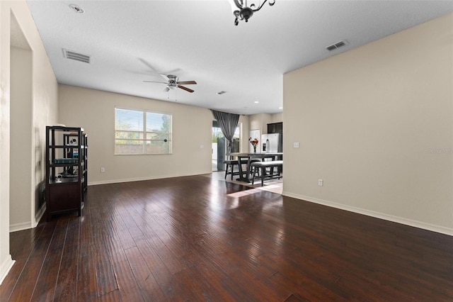 unfurnished living room featuring ceiling fan and dark hardwood / wood-style floors