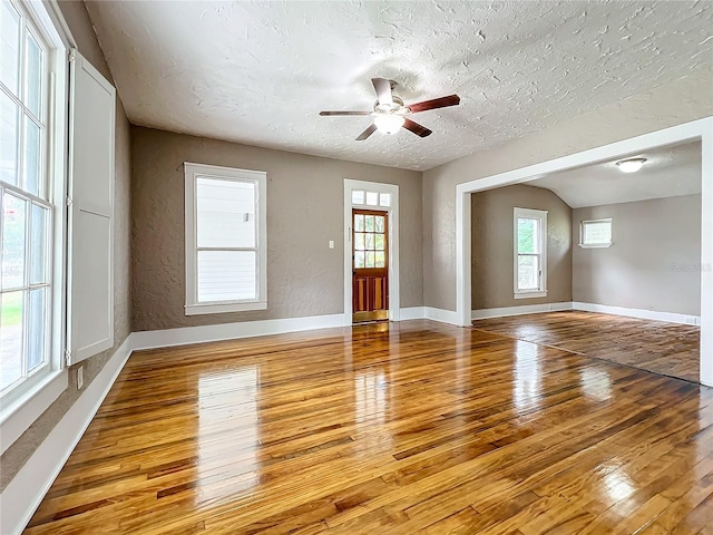 unfurnished living room with ceiling fan, light hardwood / wood-style floors, and a textured ceiling