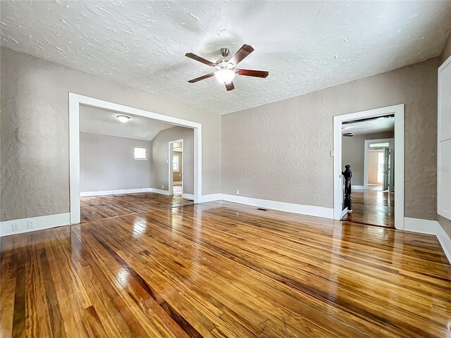 empty room with a textured ceiling, ceiling fan, and hardwood / wood-style floors