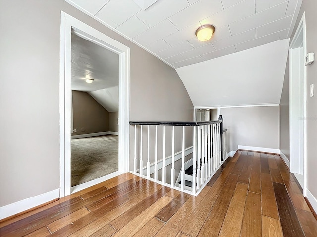 additional living space featuring wood-type flooring and vaulted ceiling