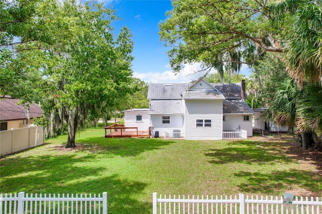 back of property with a yard and a deck