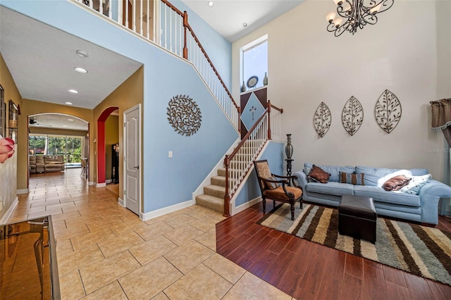 interior space featuring a towering ceiling, a notable chandelier, and light hardwood / wood-style floors