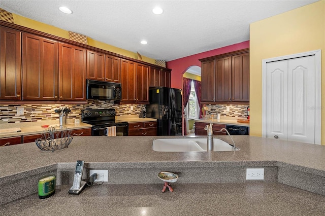 kitchen with black appliances, tasteful backsplash, sink, and a textured ceiling