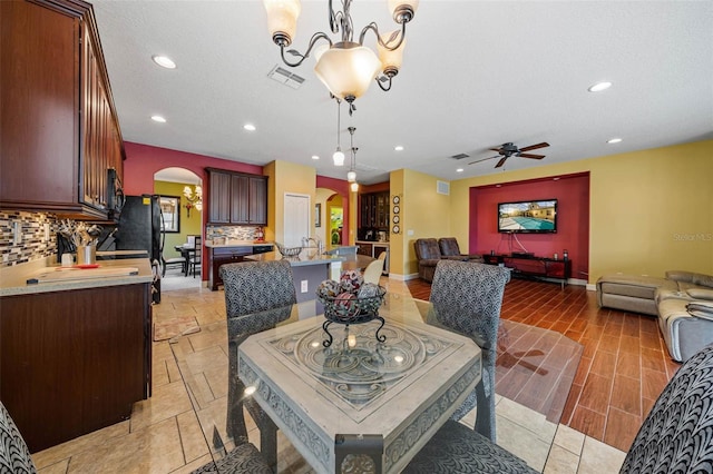 dining space featuring a textured ceiling and ceiling fan with notable chandelier